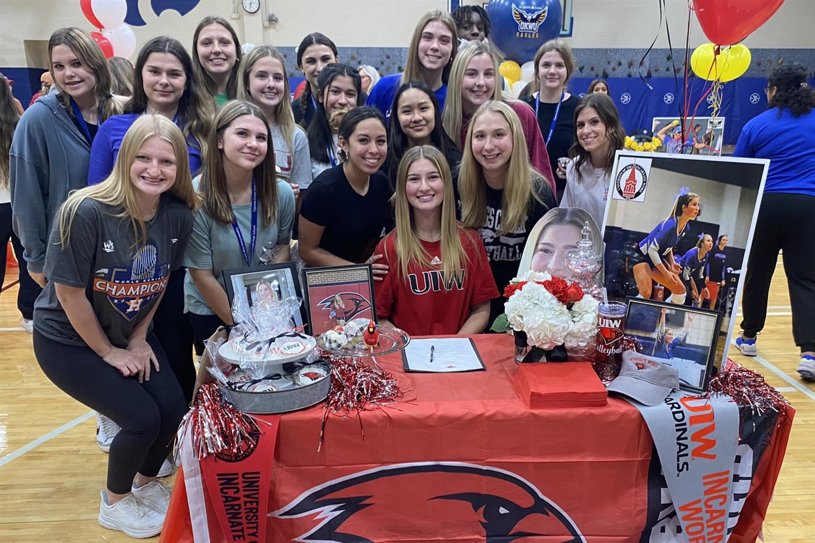 Cypress Creek High School senior Sophia Grimm, seated, poses with her teammates during the school’s signing day ceremony.